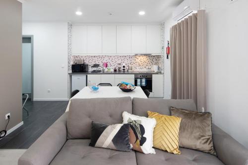 a living room with a couch and a kitchen at 58 Studio in Ribeira Grande