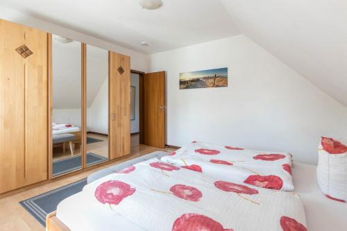 a bedroom with a bed with red flowers on it at Katharina in Westerdeichstrich