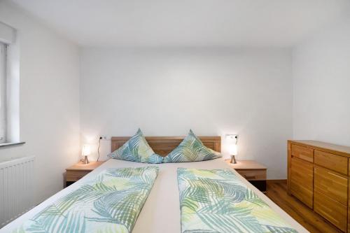 a bedroom with a bed with two night stands and two lamps at Wasgauaktiv in Schindhard