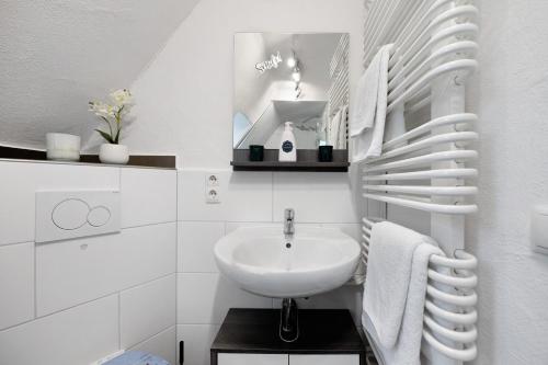 a white bathroom with a sink and a mirror at Wasgauaktiv in Schindhard