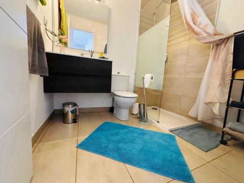 a bathroom with a toilet and a blue rug at Bungalow Aloe Dunas 2 in Maspalomas
