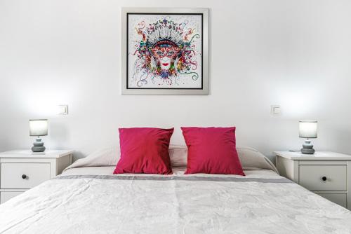 a bedroom with a white bed with red pillows at Bright in Agaete