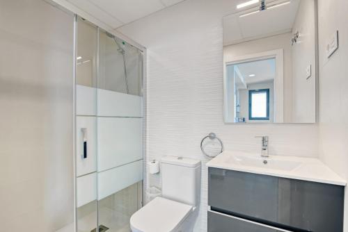 a white bathroom with a toilet and a sink at Infinium 12b in Calpe