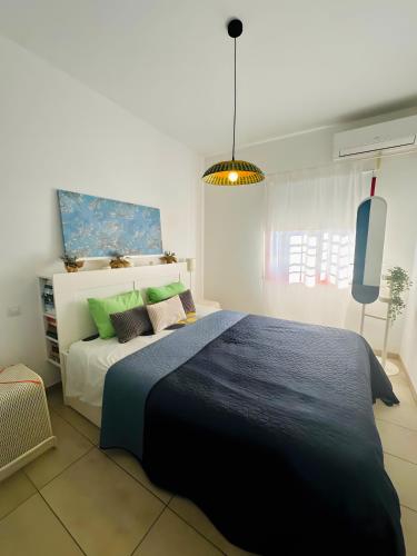 a bedroom with a large bed with a blue blanket at Bungalow Aloe Dunas 2 in Maspalomas