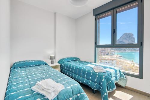 a bedroom with two beds and a view of the ocean at Infinium 12b in Calpe