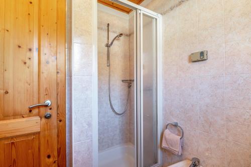 a bathroom with a shower with a glass door at Apartments Campagnola in Badia