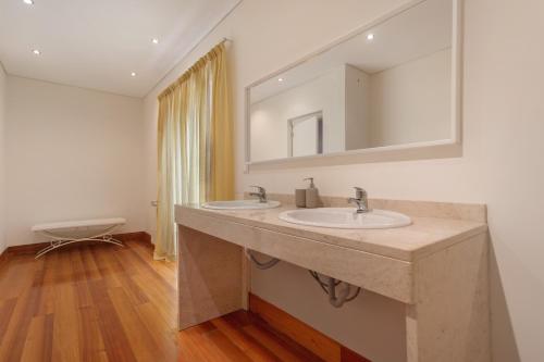 a bathroom with two sinks and a mirror at Quinta Vale do Tejo in Chamusca