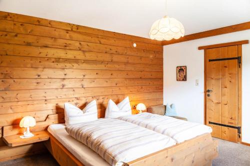 a bed in a room with a wooden wall at Anni in Leutasch