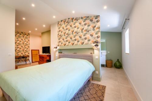 a bedroom with a bed and a wall with birds on it at Mas Saint Louis in Avignon