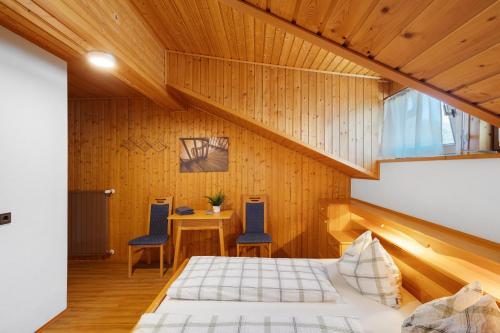 a bedroom with a bed and a table and chairs at Pension Waldheim Rooms in San Giacomo