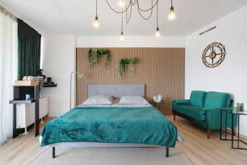a bedroom with a bed and a green chair at Global Bnb - Loft 28 Green in Augsburg