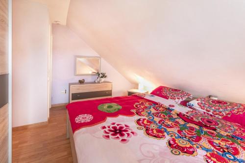 a bedroom with a bed with a red and white bedspread at Ferienhaus Ongi in Friedrichskoog-Spitze