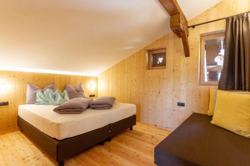 a bedroom with a bed with pillows on it at Daimlhof Ferienwohnung Moosherz in Völs am Schlern