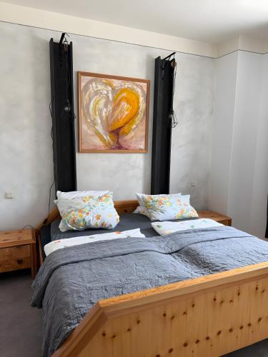 a bedroom with a bed with a painting on the wall at Appartement Neunkirchen City in Neunkirchen