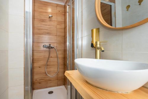 a bathroom with a white sink and a shower at Refúgio Das Barcas in Lourinhã