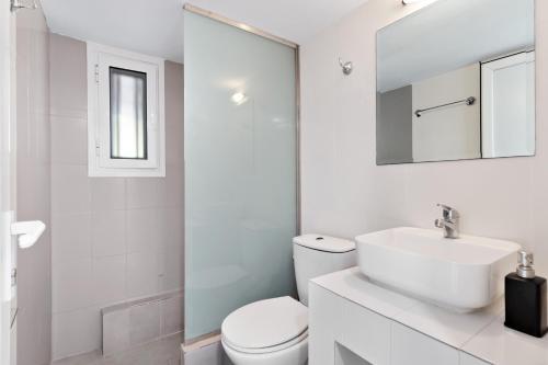 ein weißes Badezimmer mit Toilette und Waschbecken in der Unterkunft Villa Jimmy's Katomeri 2 in Meganisi