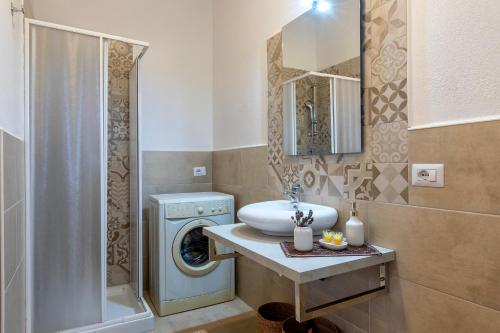 a bathroom with a sink and a washing machine at Domo Clelia in Nulvi