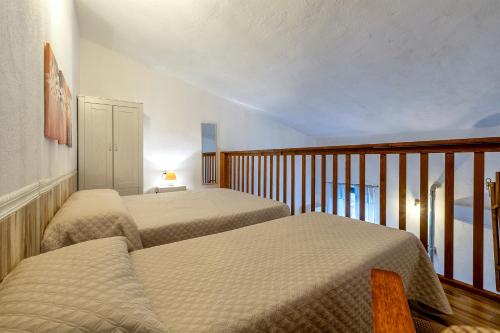 a bedroom with two beds and a balcony at Domo Clelia in Nulvi
