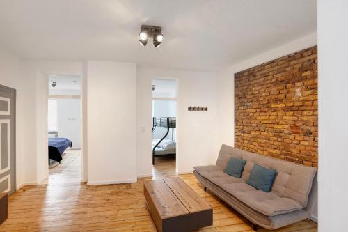 a living room with a couch and a brick wall at Ferienwohnung Rheinschlendern in Rüdesheim am Rhein