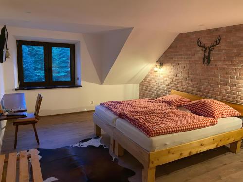 a bedroom with a bed and a brick wall at Bergwiesnblick Apartments in Bärenstein