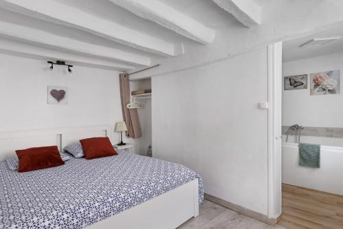 a white bedroom with a bed and a bath tub at Gite Cocon et Balnéo in Selles-sur-Cher