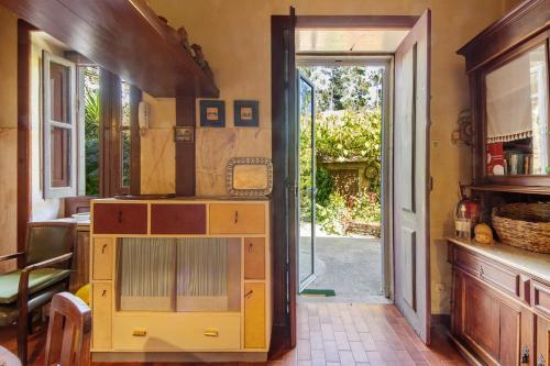 a kitchen with a yellow cabinet and an open door at Guest House Casa S Martinho in Oliveira de Azemeis