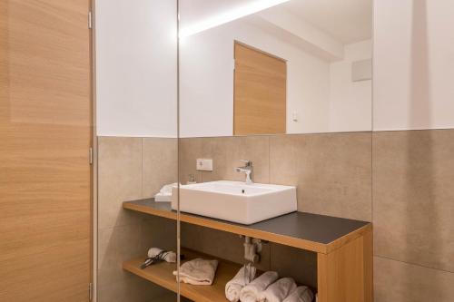 a bathroom with a sink and a mirror at Ferienwohnungen Karin - Golden in Termeno