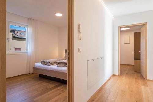 a small bedroom with a bed and a mirror at Ferienwohnungen Karin - Golden in Termeno