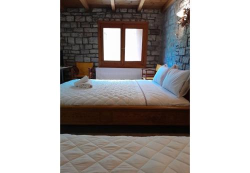 a bedroom with a large bed with a window at Tsarouxi village 2 in Karditsa
