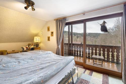 a bedroom with a bed and a large window at Ferienwohnung Sankt Hubertus in Bad Berneck im Fichtelgebirge