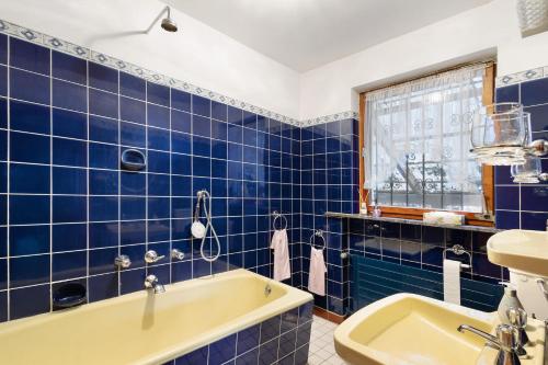 a blue tiled bathroom with a tub and a sink at Ferienwohnung Sankt Hubertus in Bad Berneck im Fichtelgebirge