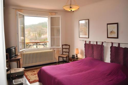 a bedroom with a purple bed and a window at Gîte Marion in Allemagne-en-Provence