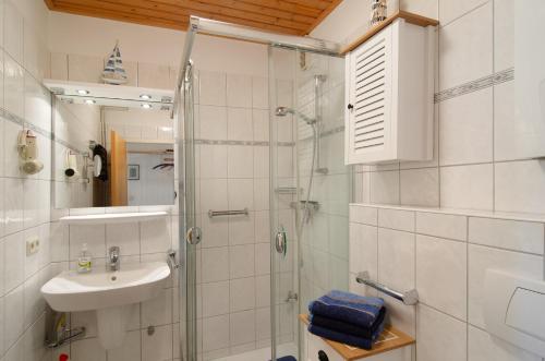 a white bathroom with a shower and a sink at Ferienhaus Piet in Berumbur