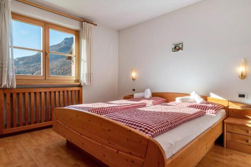 a bedroom with two beds and a large window at Apartments Campagnola in Badia