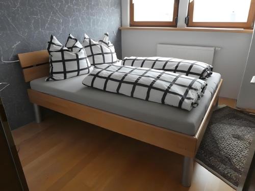 a bed with black and white pillows on it at Ferienwohnung Diepold in Wasserburg
