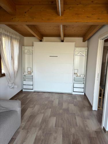 a large white door in a room with wooden ceilings at La Depandance con Giardino Pescara in Spoltore