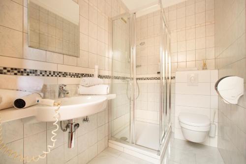 ein Bad mit einer Dusche, einem Waschbecken und einem WC in der Unterkunft Hotel Restaurant Schachenwald in Premstätten