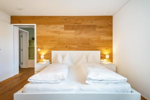 a bedroom with a white bed with two pillows at Ferienwohnung Lauterach in Lauterach