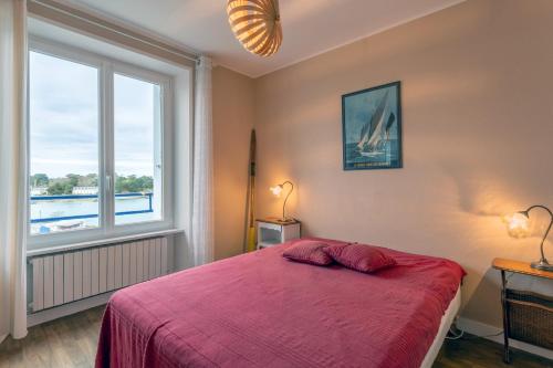 a bedroom with a bed and a large window at Appartement face Mer - 50m plage in Douarnenez