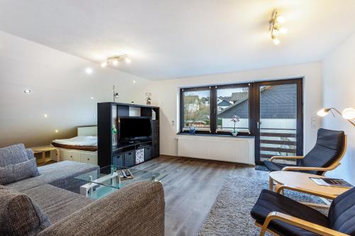 a living room with a couch and a tv at Lydias Ferienwohnung in Schmallenberg
