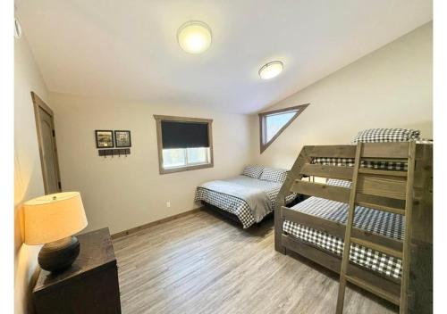 a bedroom with two bunk beds and a desk at Sunny Peaks in Valemount
