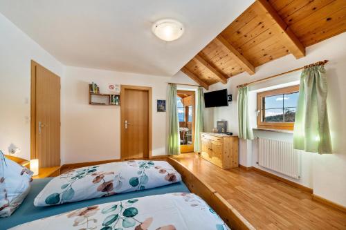 a bedroom with two beds and a television at Wohnung Arnika Stücklhof in San Genesio Atesino
