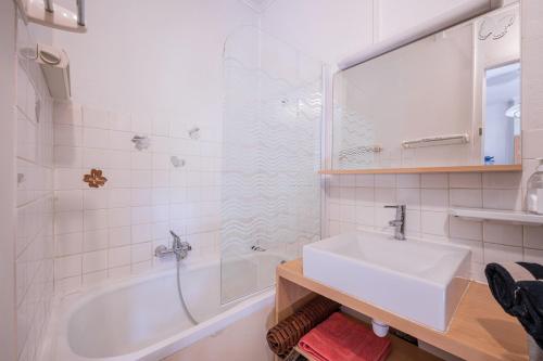 a bathroom with a tub and a sink and a shower at Rose Des Neiges in Valloire