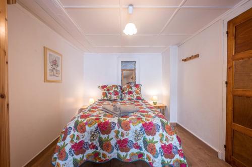 a bedroom with a bed with a colorful comforter at Rose Des Neiges in Valloire