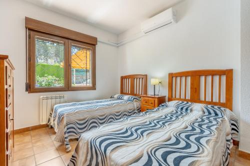 a bedroom with two beds and a window at Villa Leonor con piscina privada in Monachil