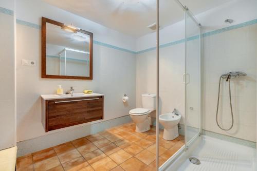 a bathroom with a toilet and a sink and a shower at Villa Leonor con piscina privada in Monachil