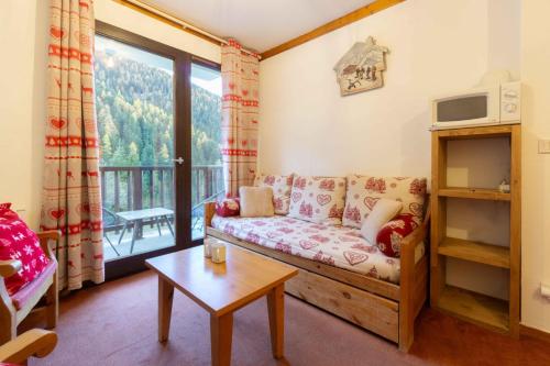 a living room with a couch and a balcony at Appart valfrejus in Modane