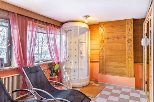 a bathroom with a shower and a chair in a room at Berggold in Nesselwängle