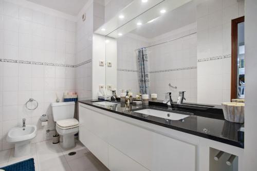 a white bathroom with a sink and a toilet at Casa do Mar na Figueira da Foz in Figueira da Foz