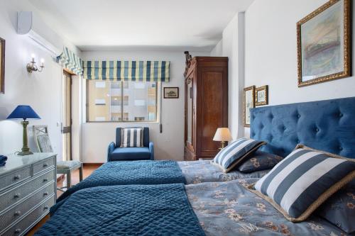 a bedroom with a blue bed and a blue chair at Casa do Mar na Figueira da Foz in Figueira da Foz